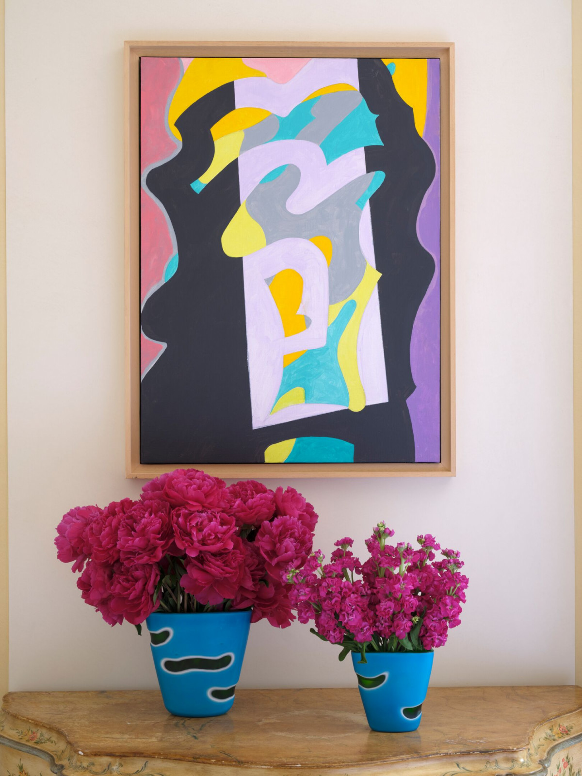 Contemporary abstract artwork displayed with custom ceramic planters on an antique painted Venetian chest