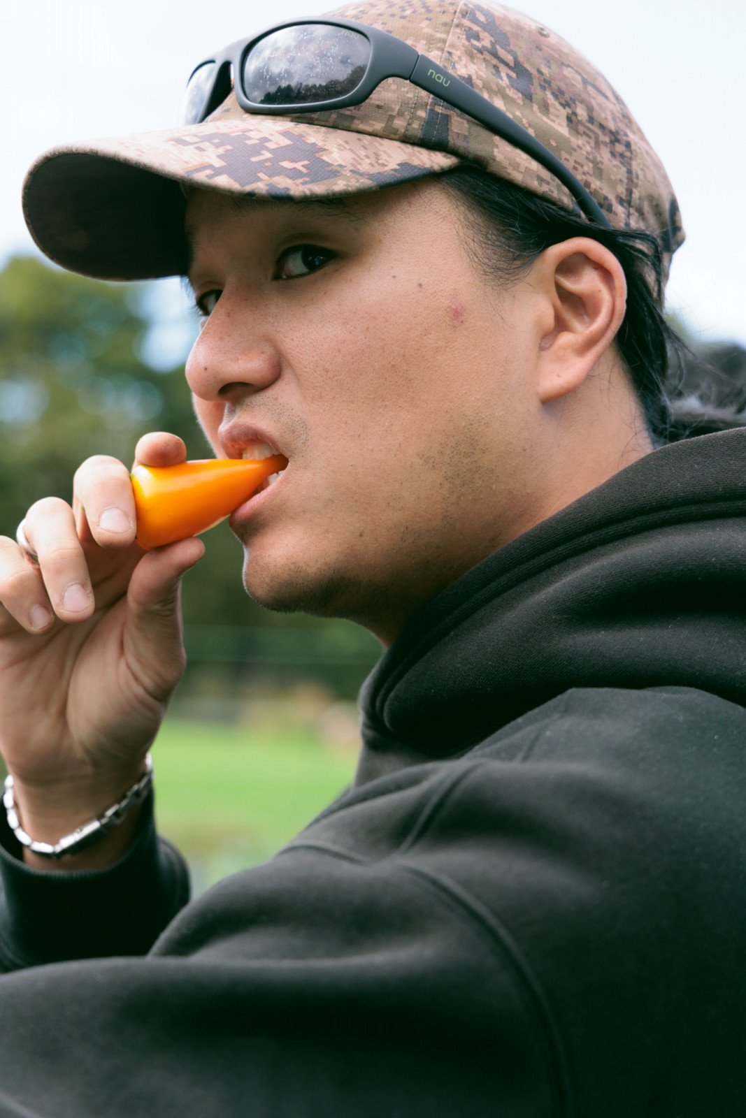 Chef Kyumin Hahn crunching into a fruity yellow bell pepper from Duca Farm