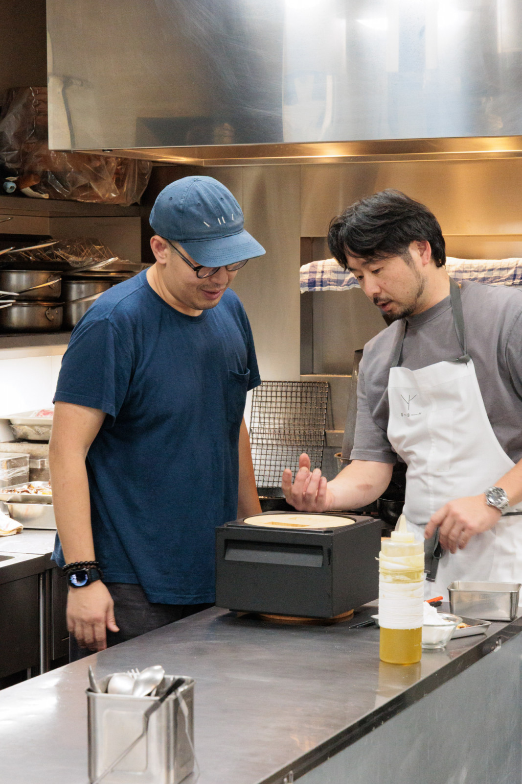 Chef Masashi Okamoto lends chef Kwang Uh his carbon donabe pot for his bibimbap