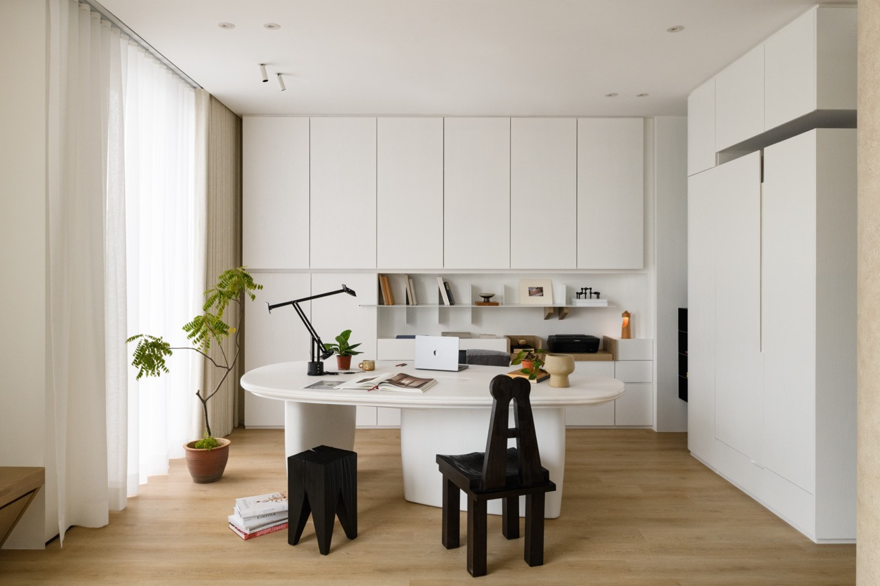 A home office features the signature curved desk and sculptural seating