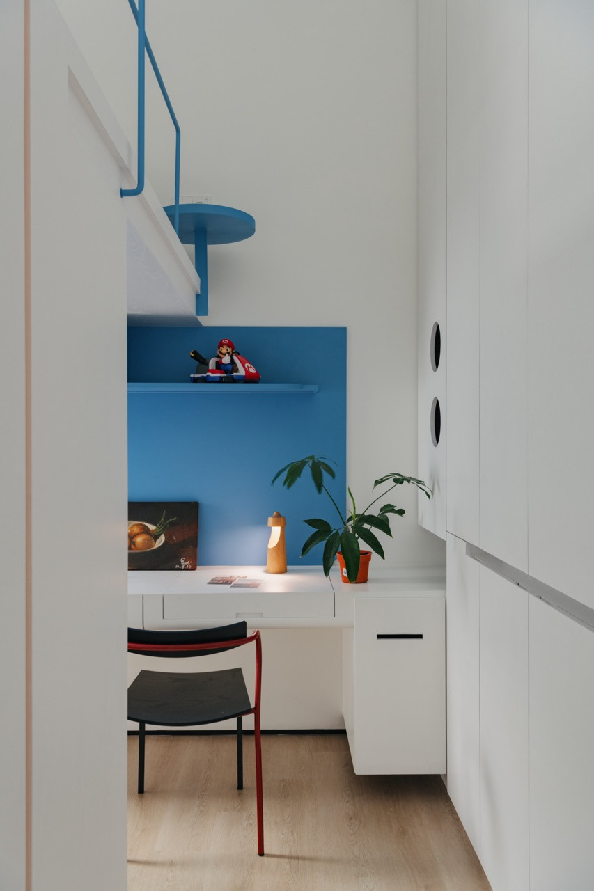 A child’s study area features the same vibrant blue palette, complete with playful Mario figurines that reflect the home’s embrace of personality within its clean, modern framework