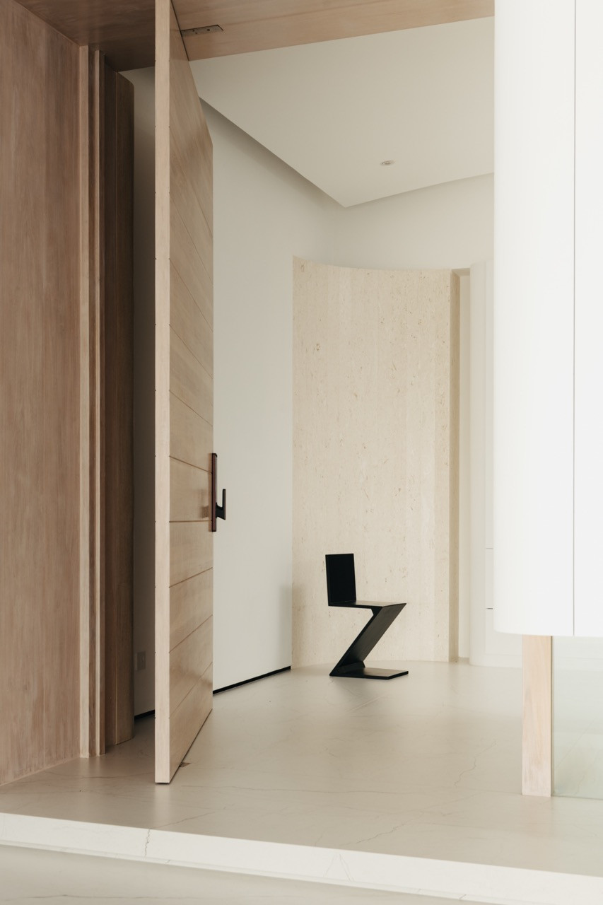 A glimpse through a timber-framed doorway reveals one of the zigzagging chairs