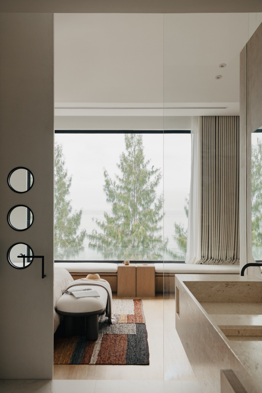 The master bedroom showcases the seamless connection to the bathroom and a prominent window seat