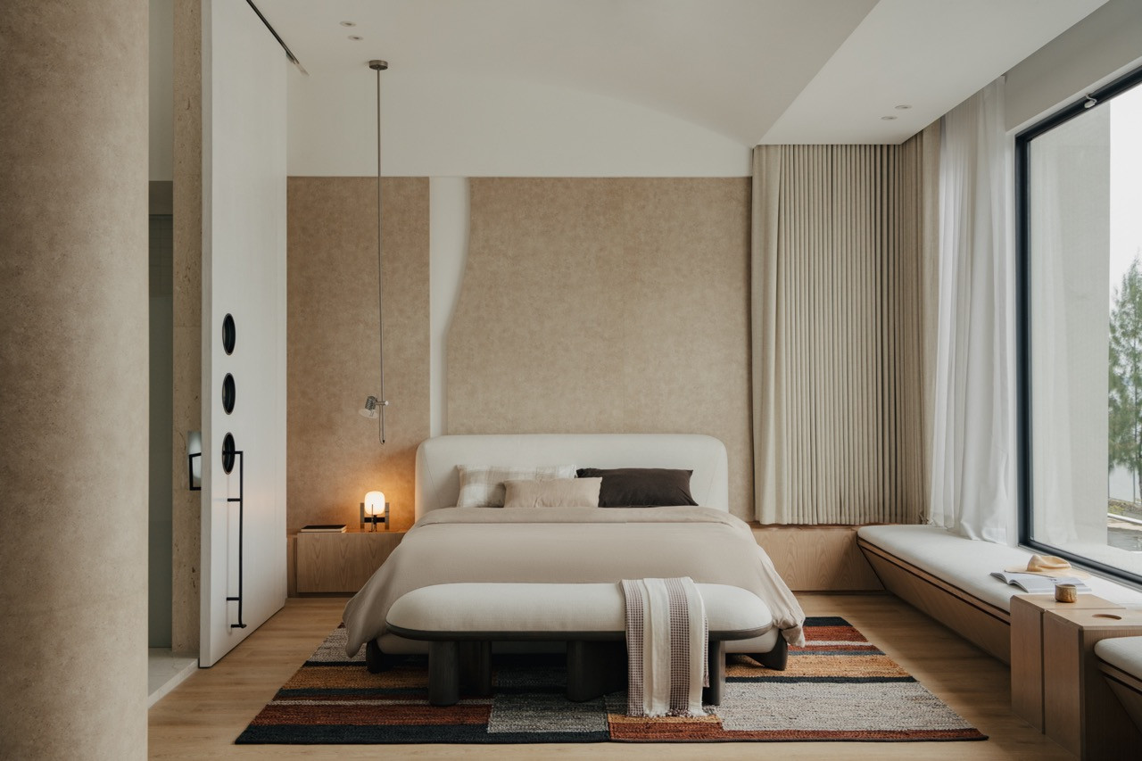 The master bedroom’s neutral tones and geometric patterns create a blank canvas environment