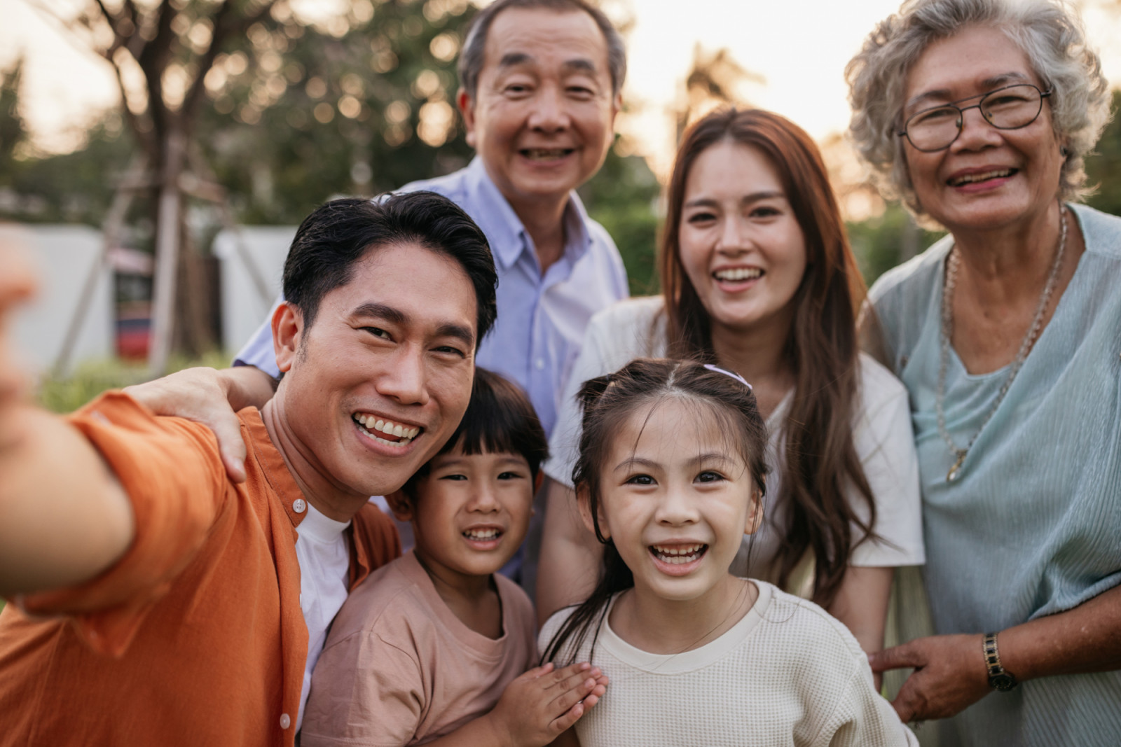 Smiling family is taking selfies in the yard.