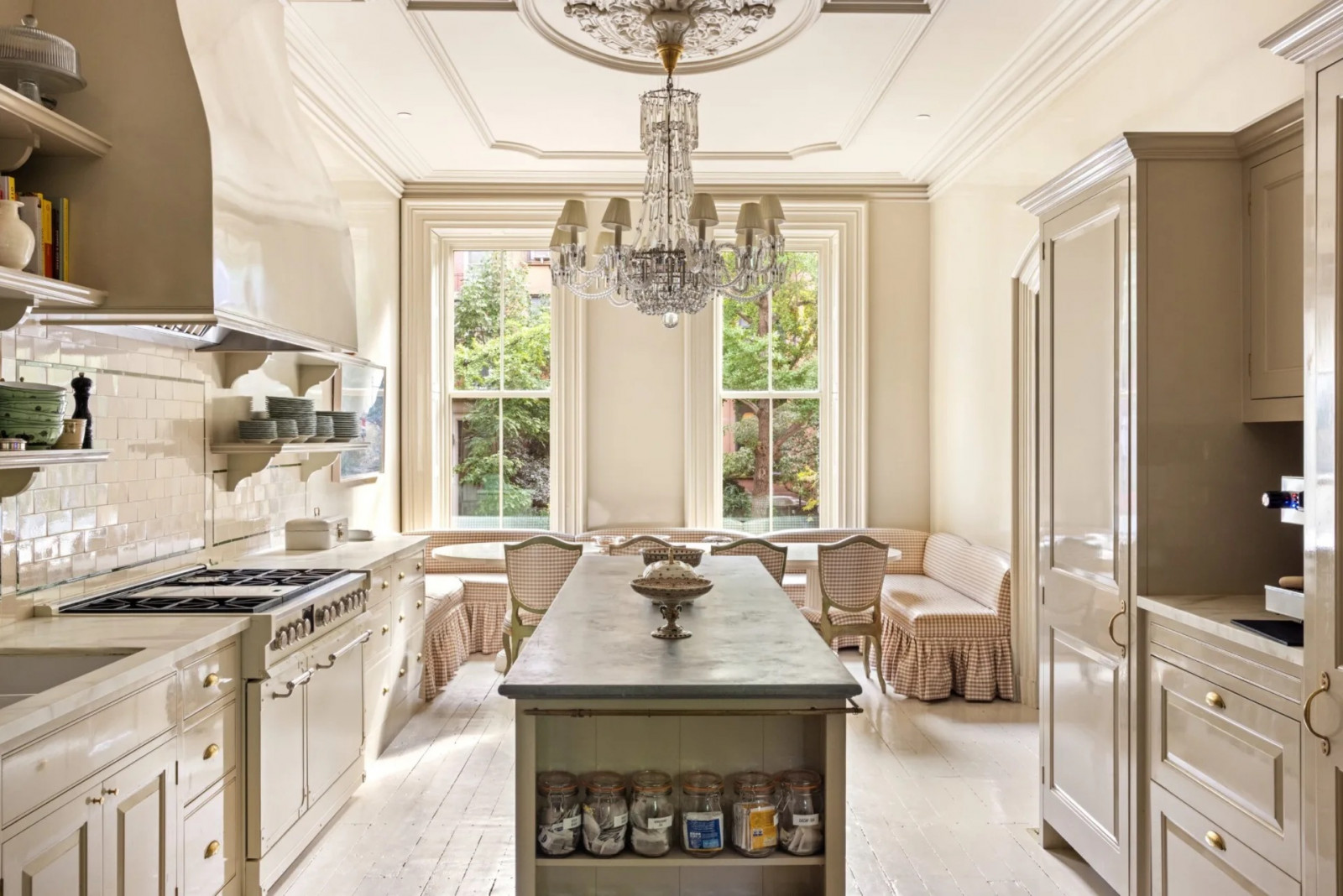 An original ceiling rose anchors a chandelier above the kitchen island, while oversized windows flood the dining area with natural light (Photo: The Gambino Group)