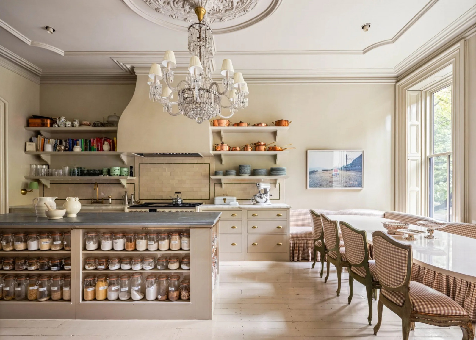 A custom-built banquette with checkered upholstery provides dining seating beneath the kitchen's ornate ceiling details (Photo: The Gambino Group)