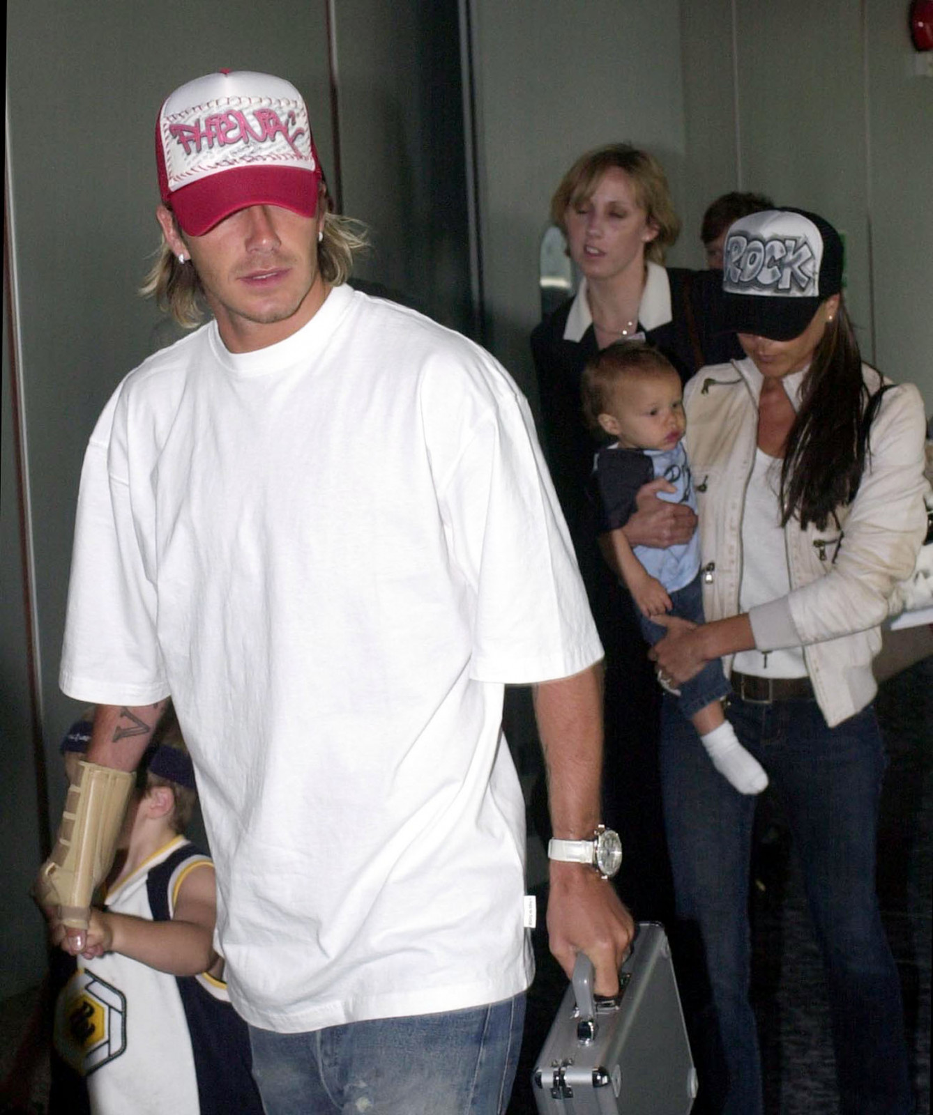 Footballer David Beckham with his son Brooklyn is followed by his wife Victoria (right) and baby Romeo on arrival at Heathrow Airport from Los Angeles. (Photo by Tim Ockenden - PA Images/PA Images via Getty Images)