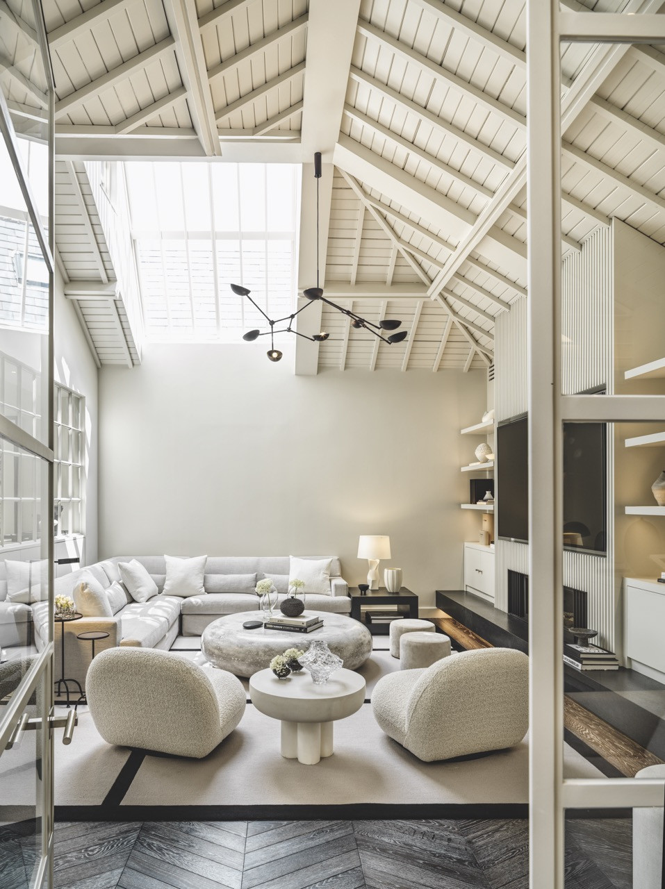 The main living area features lofty heights and lots of sunlight, with integrated shelving maintaining the sense of openness here
