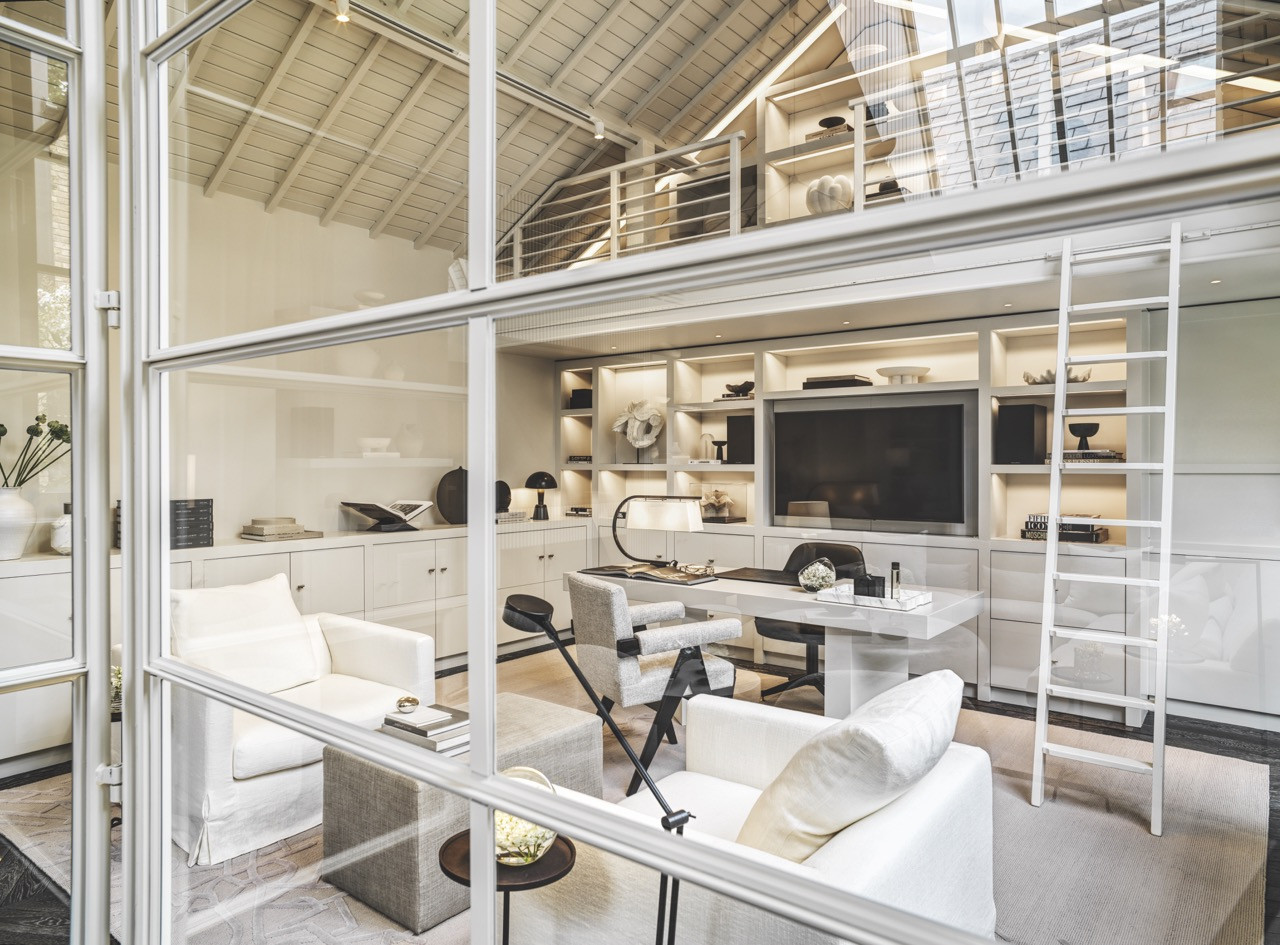 The glass partition system facilitates views between the office and the main living areas while maintaining separation, with B&B Italia Maxalto furniture and integrated lighting creating a stylish workspace within the open-plan layout