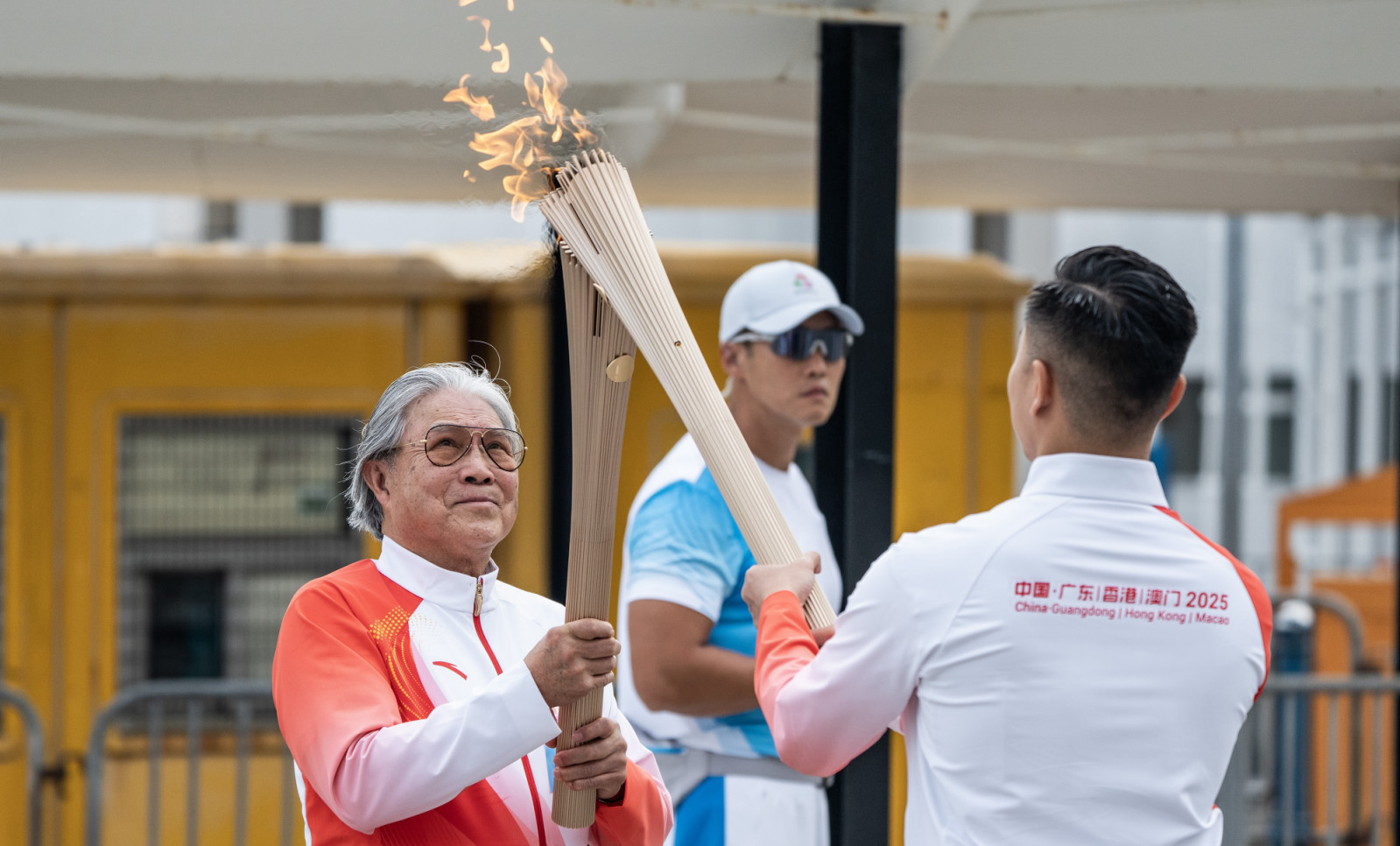HONG KONG, CHINA - NOVEMBER 02: Timothy Fok Tsun-ting (L), president of the Sports Federation and Olympic Committee of Hong Kong, China, participates in the torch relay for the 15th National Games of China on November 2, 2025 in Hong Kong, China. The torch relay is held simultaneously in four locations: China's Hong Kong and Macao special administrative regions and the cities of Guangzhou and Shenzhen in Guangdong Province. (Photo by Hou Yu/China News Service/VCG via Getty Images)