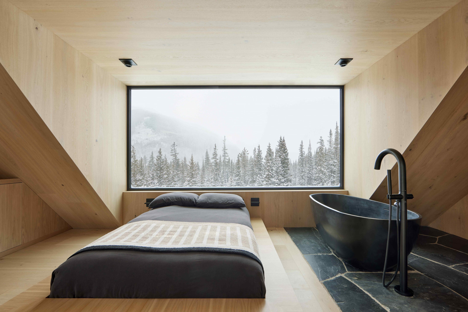 Custom, built-in furniture in the bedroom uses the same white oak material