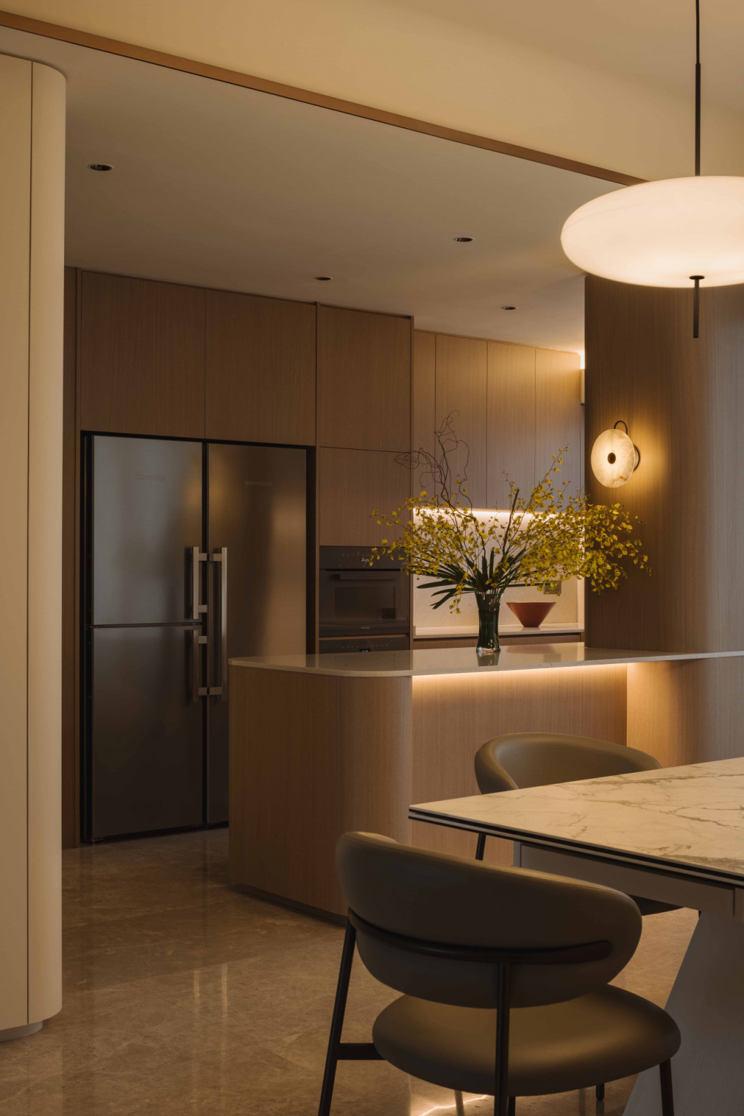 The Newton One apartment’s kitchen glows invitingly in the evening