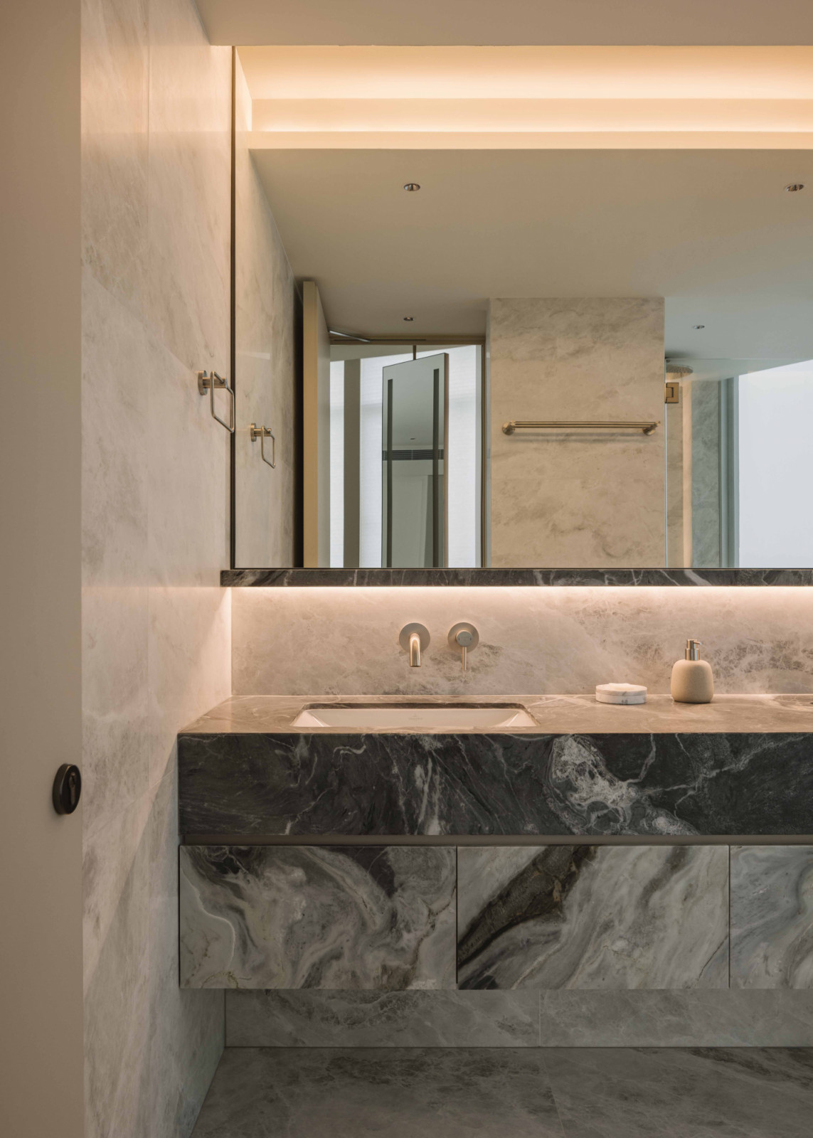 Tone-on-tone marble surfaces with graphic veining create a simple yet sumptuous bathroom
