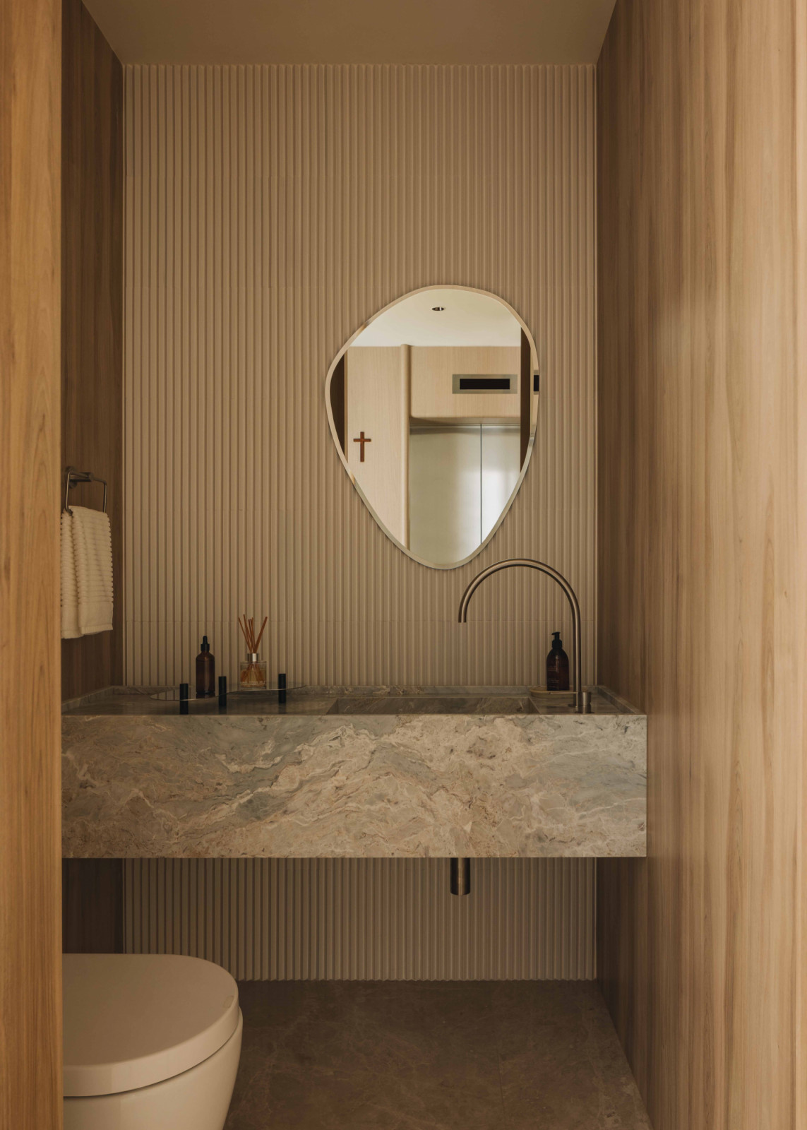 An organic-shaped mirror softens the Newton One apartment’s rectilinear bathroom