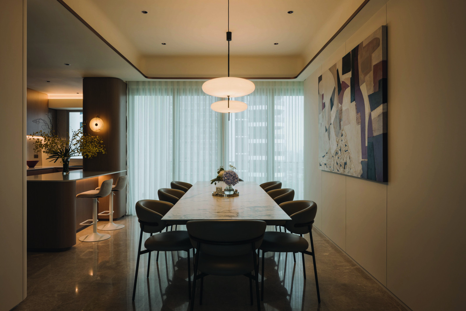 The dining area encapsulates the overarching design identity of the home with its elegant scheme and gentle illumination