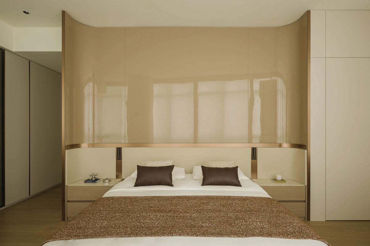 The master bedroom features a curving, cocooning wall that evokes a restful sleeping area