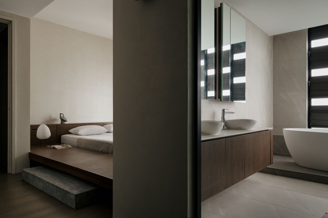 Sightlines connect the bedroom to the ensuite bathroom, creating visual depth across the Japanese-inspired apartment