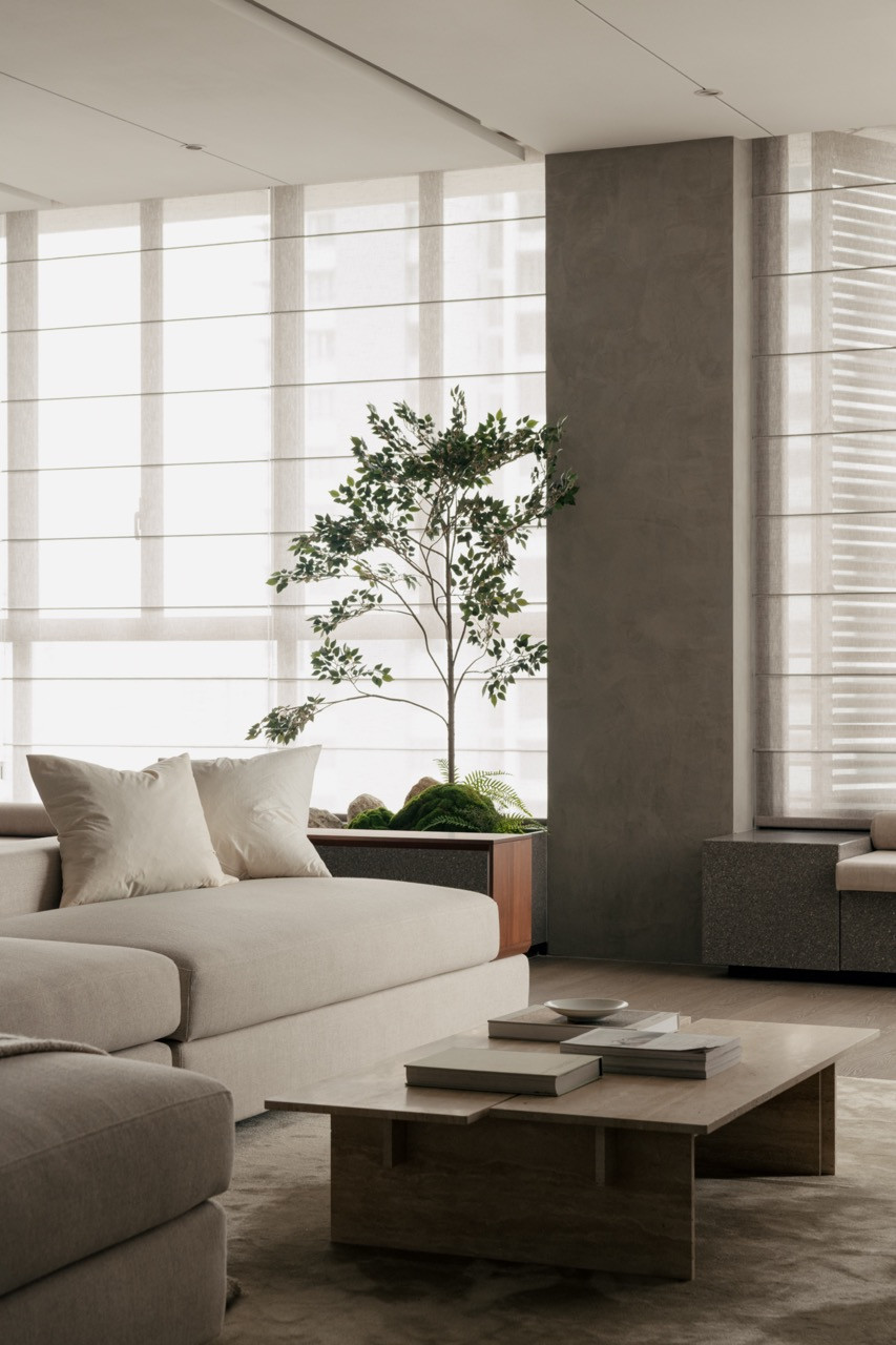 Linen Roman blinds and external shutters control Malaysian daylight in the living room, where granite window benches provide seating
