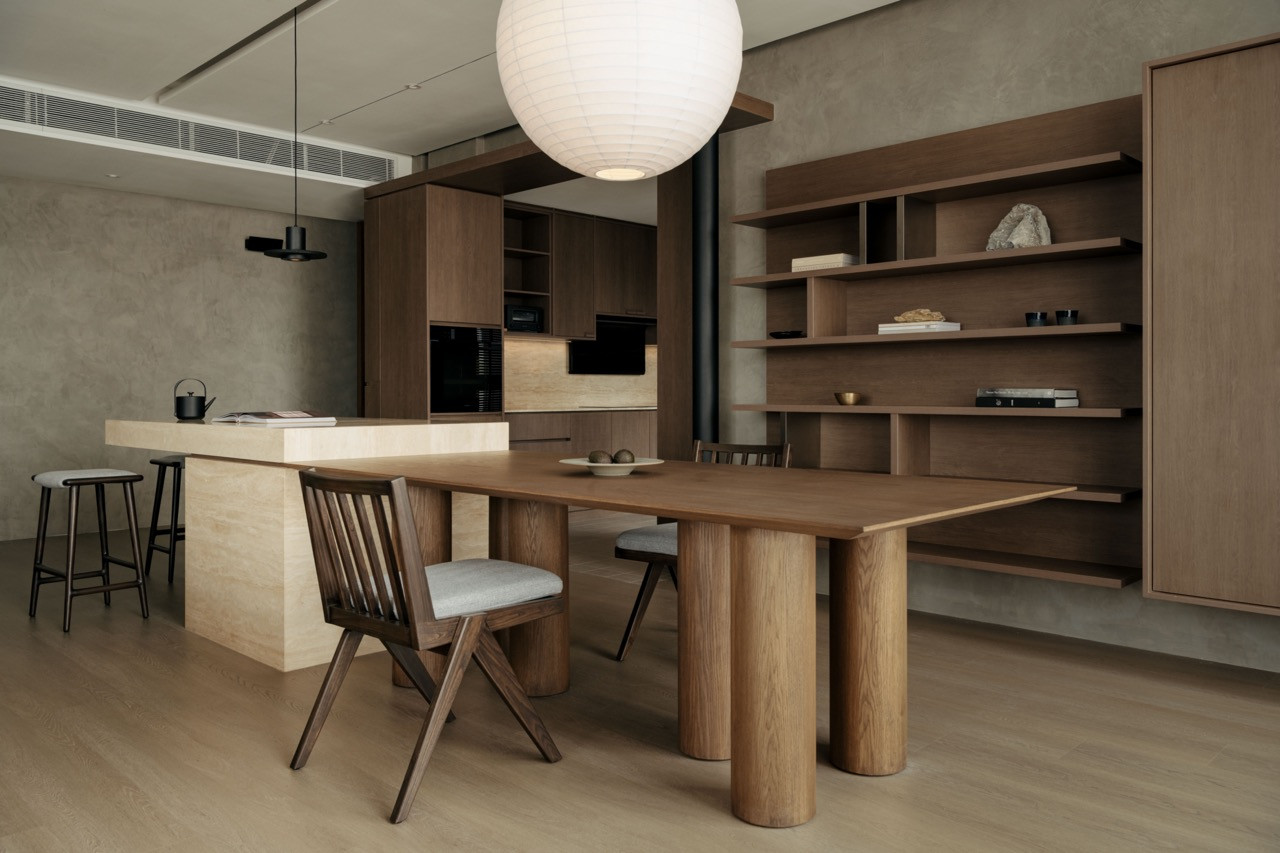 The dining area sits beneath an oversized Japanese paper lamp, with oak shelving defining the space adjacent to the kitchen
