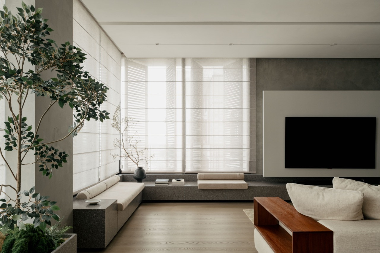 A cement column punctuates the open living area, with the TV wall and granite window seating defining distinct zones