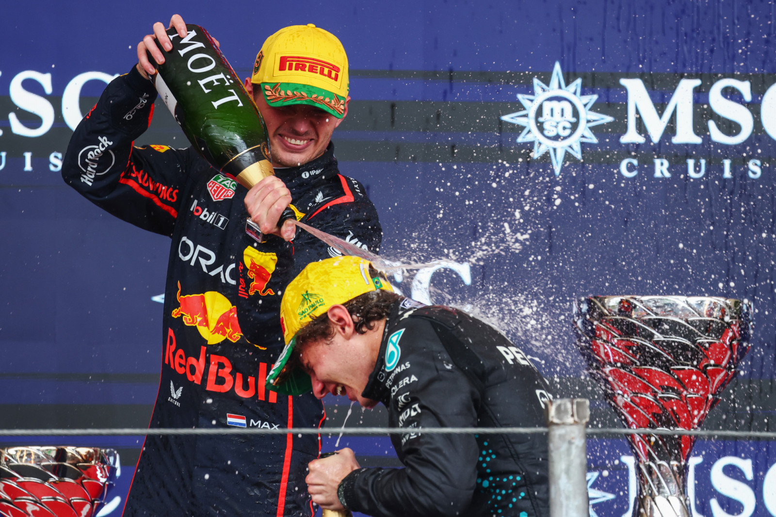 SAO PAULO, BRAZIL - NOVEMBER 09: Second placed Andrea Kimi Antonelli of Italy and Mercedes AMG Petronas F1 Team and Third placed Max Verstappen of the Netherlands and Oracle Red Bull Racing celebrate on the podium with Champagne during the F1 Grand Prix of Brazil at Autodromo Jose Carlos Pace on November 09, 2025 in Sao Paulo, Brazil. (Photo by Mark Thompson/Getty Images)