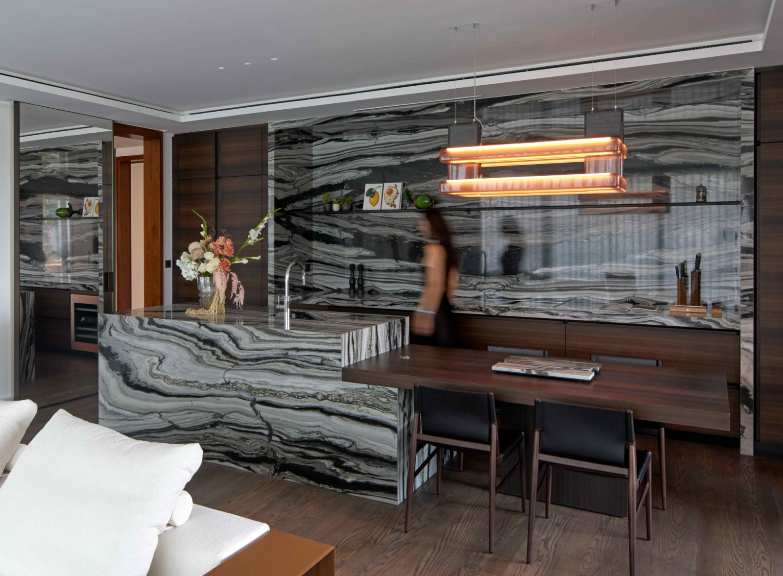 Laurids Gallée’s lighting piece and bespoke wooden cabinetry anchor the expressive veining of the marble countertops