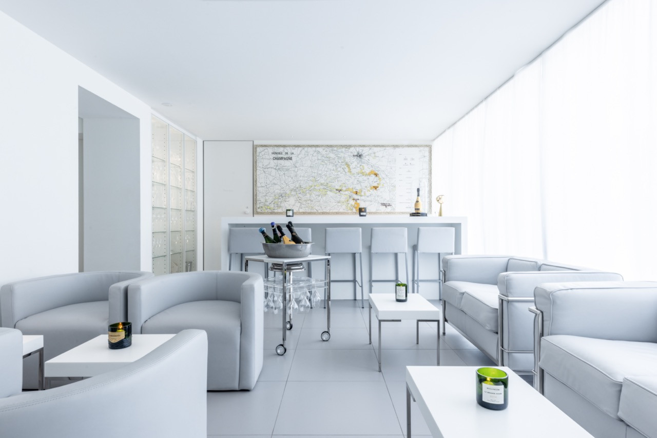 The lounge incorporates champagne references throughout, including a vintage Champagne region map and a bar cart