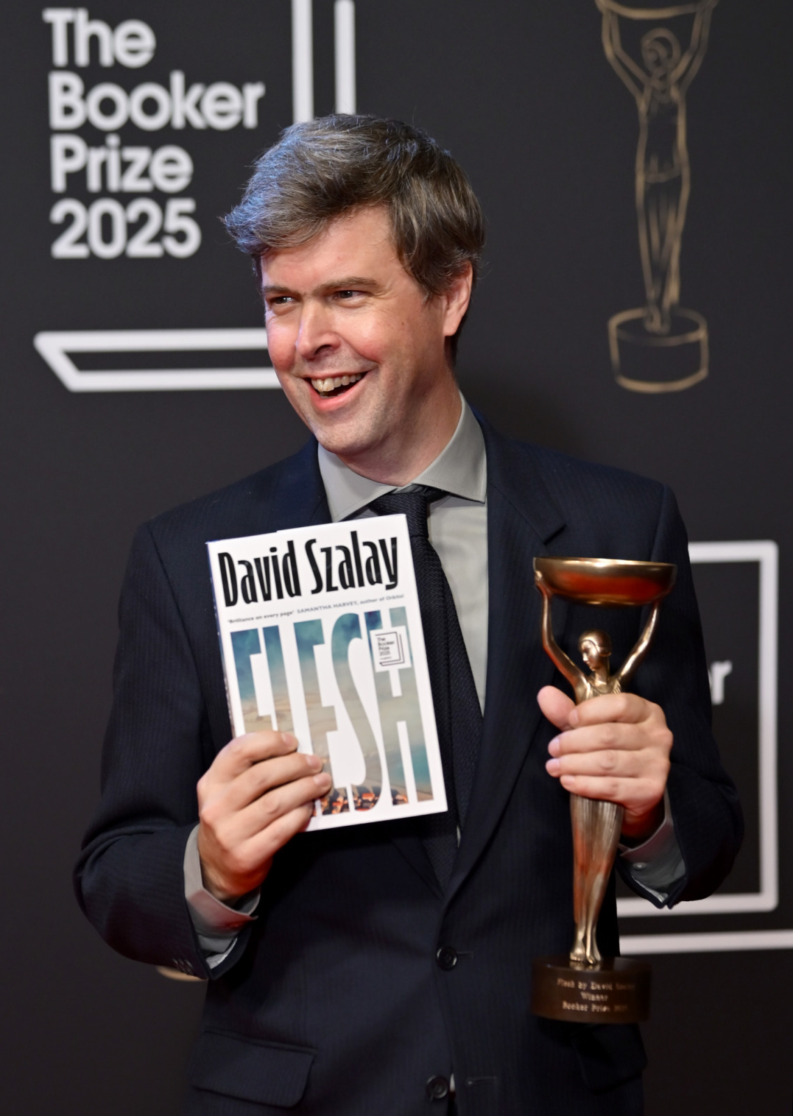 LONDON, ENGLAND - NOVEMBER 10: Booker Prize 2025 winner David Szalay, author of "Flesh" celebrates with the award and book during The Booker Prize 2025 Ceremony at Old Billingsgate on November 10, 2025 in London, England. (Photo by Eamonn M. McCormack/Getty Images)