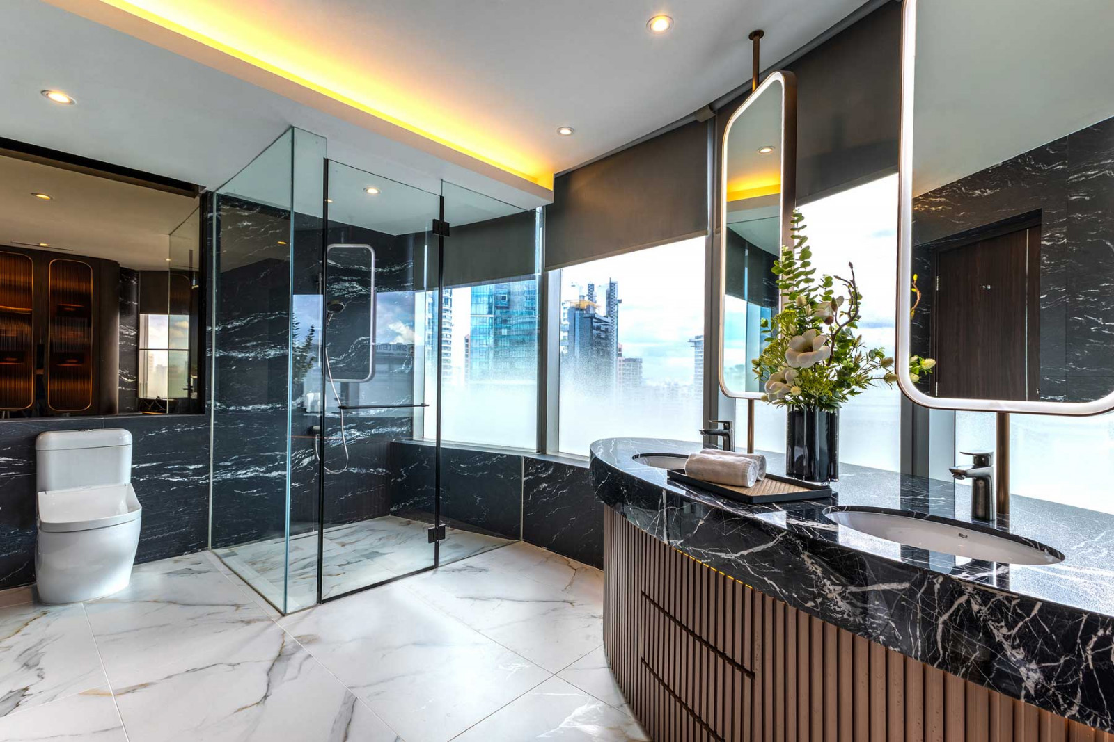 Polished black marble defines this spacious bathroom, which also features breathtaking views of the cityscape