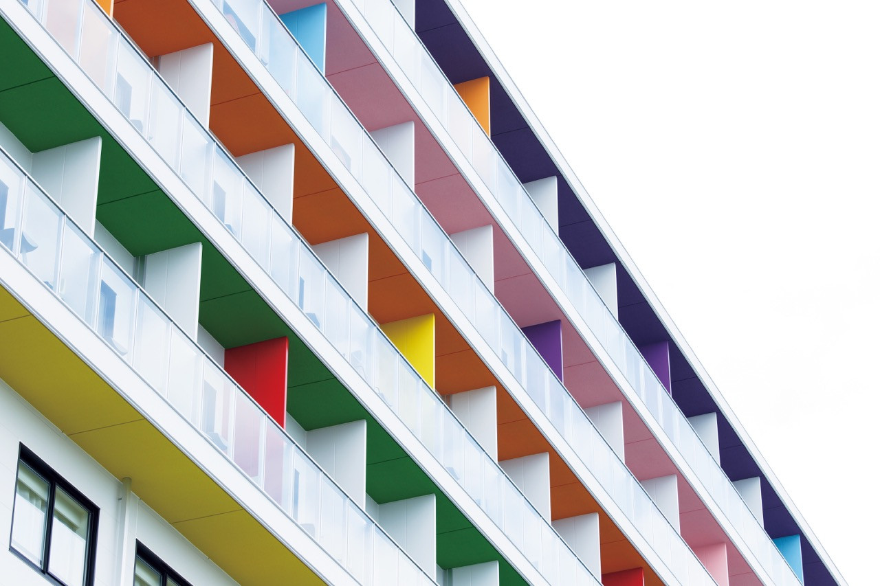 Coloured balconies on the hotel facade where the exterior design responds to the athletic context of the velodrome site.