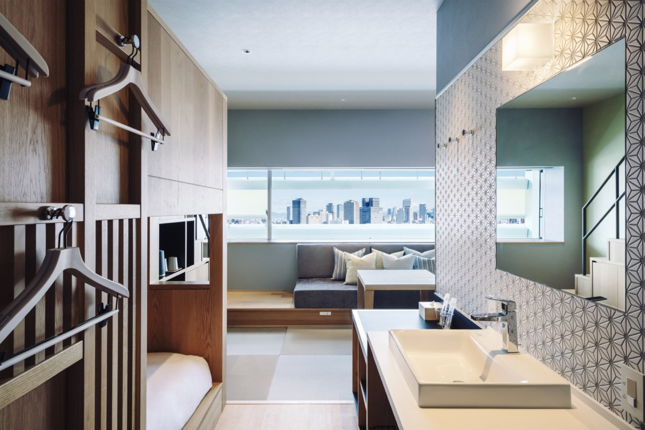 Guest room interiors by Azuma Architect & Associates use timber screens and geometric tile patterns and the raised seating area frames views towards the city