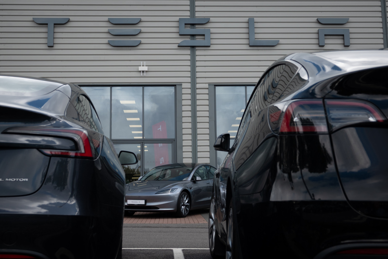 BRISTOL, UNITED KINGDOM - OCTOBER 01: New and used Tesla cars are displayed outside a dealership, on October 1, 2025 in Bristol, England. Helped by government grants fully electric or hybrid vehicles made up more than half of all new car registrations in previous months. The government's commitment to reducing future Co2 carbon emissions will mean many more motorists will need to switch from petrol and diesel powered cars to electric (EV) driven ones. However there are also fears that the charging network i