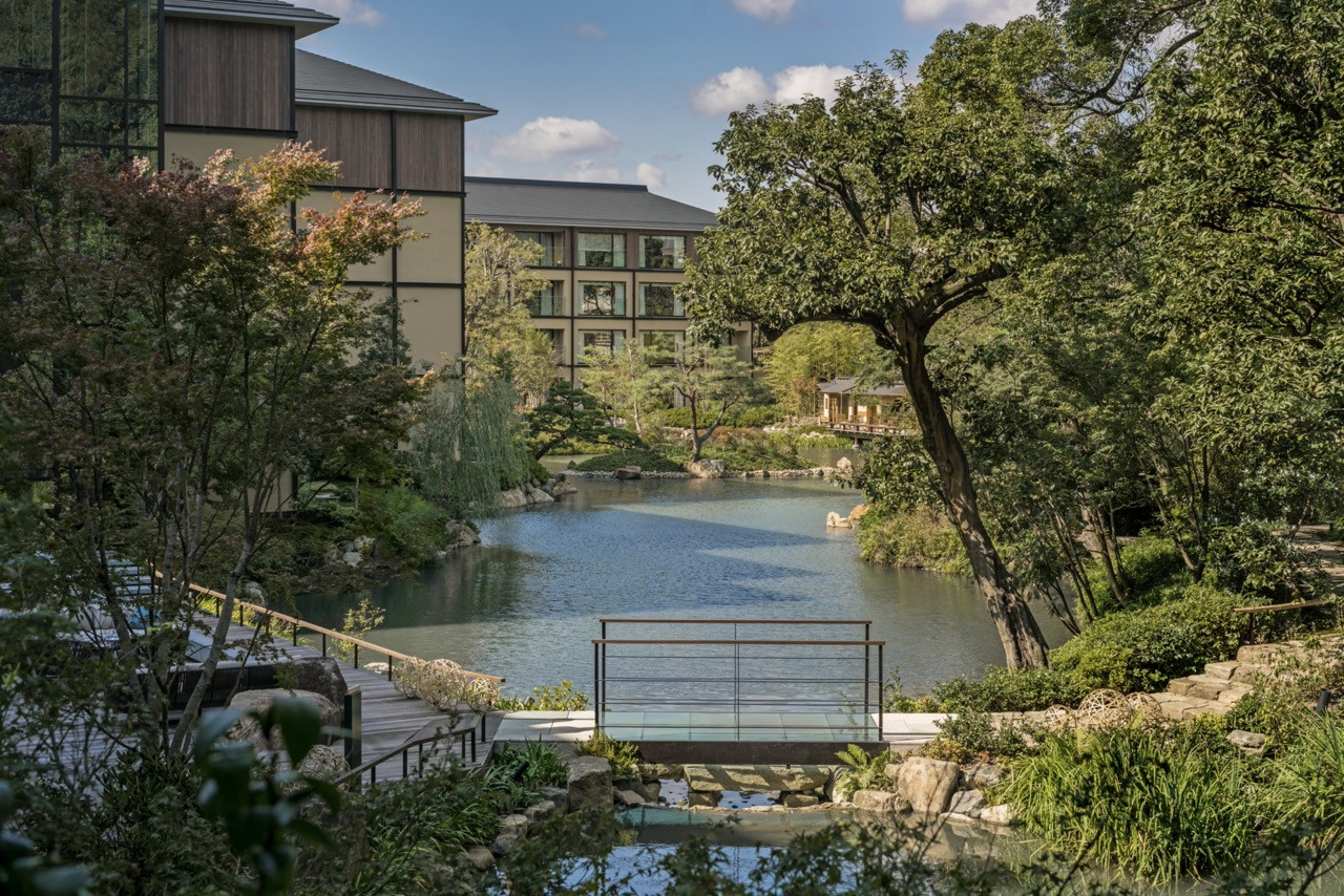 The hotel overlooks the historic pond garden, with pathways and decks connecting the contemporary architecture to the centuries-old landscape