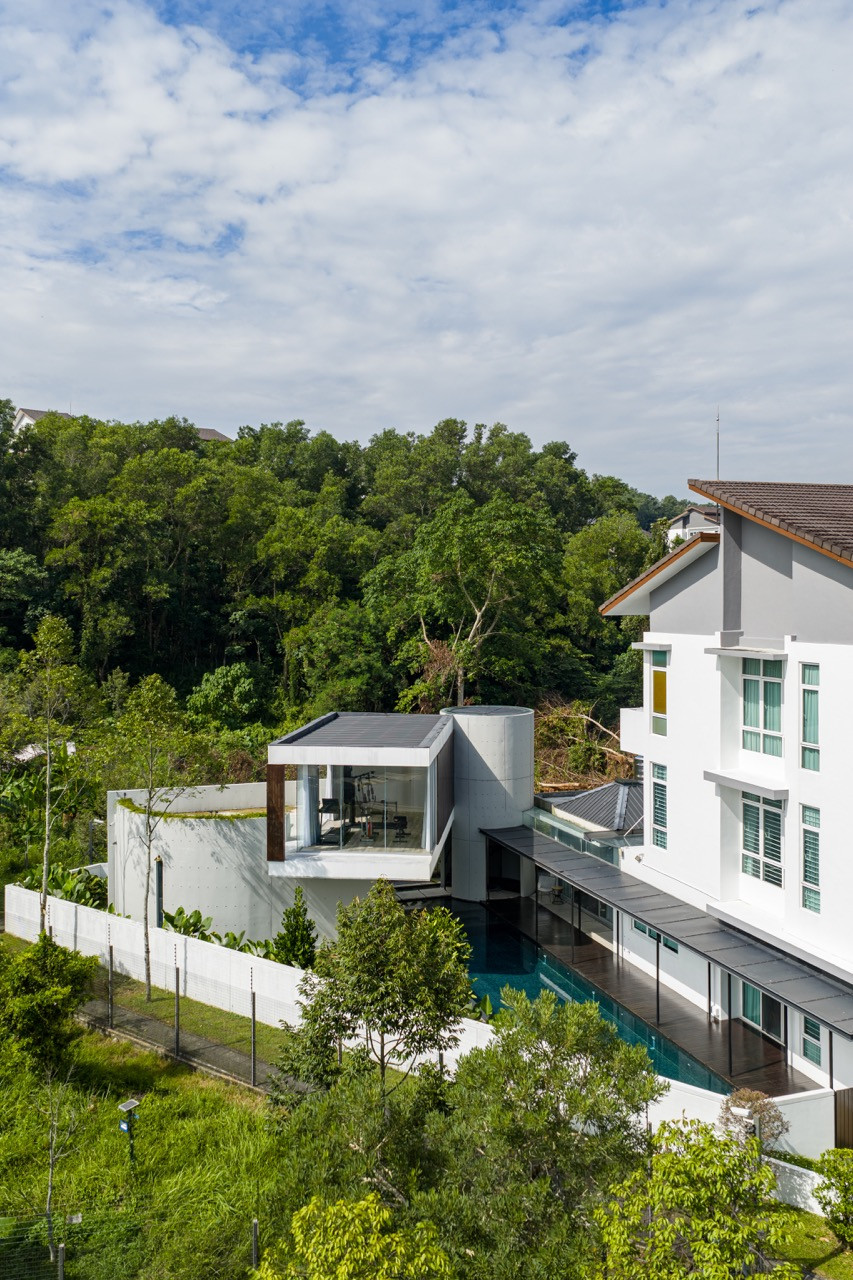The new pavilions connect to the existing corner lot house with the forest providing a natural backdrop