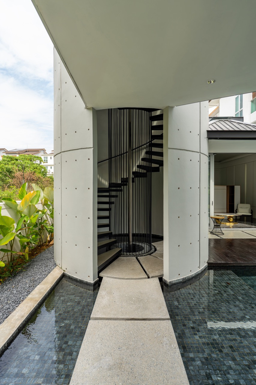 The spiral staircase leads to the rooftop garden with forest views beyond