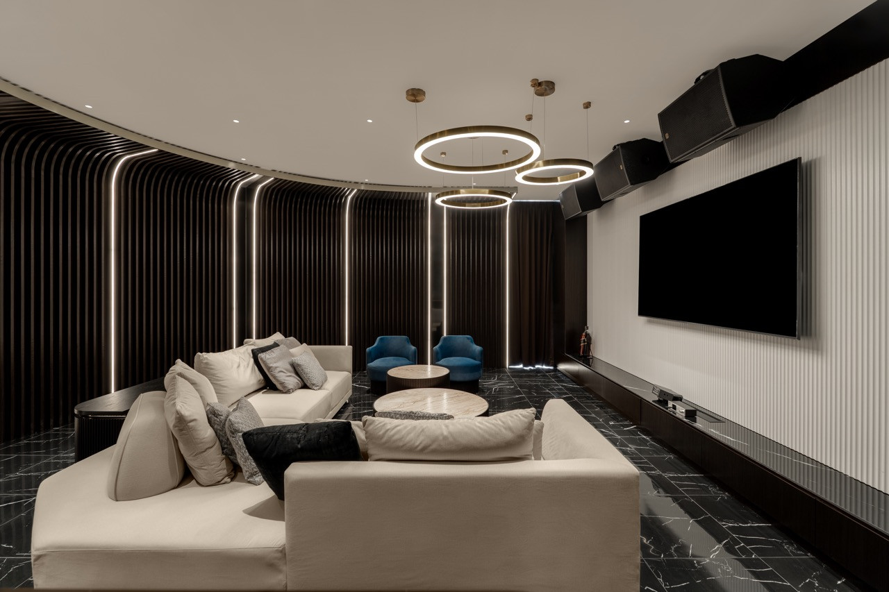 The home theatre room features curved seating and ambient lighting