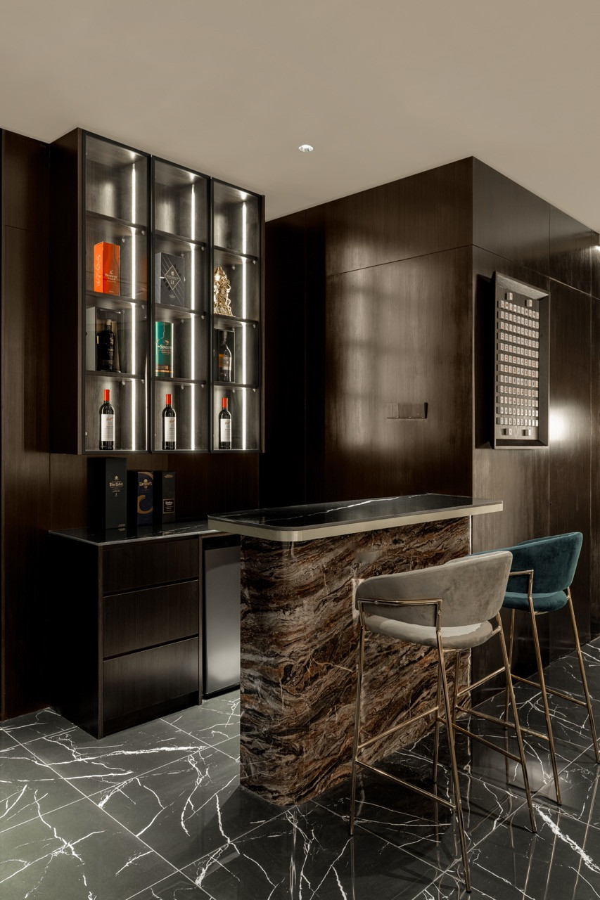 A bar area with a backlit wine display and a marble counter serves the entertainment pavilion