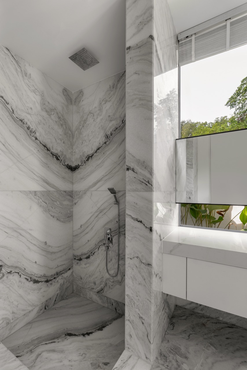 The shower areas open to the forest through high windows