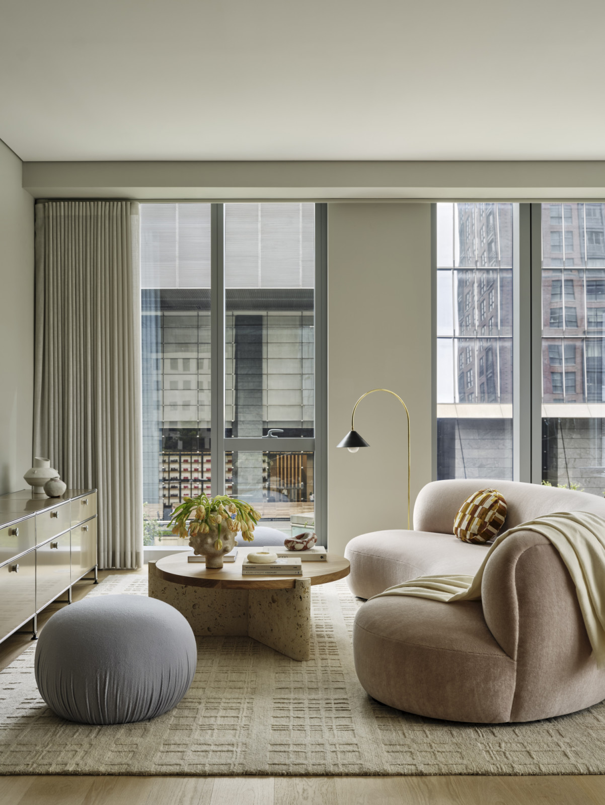 A living room with organic shapes and neutral hues at a pied-à-terre above the High Line in New York City designed by Lucy Harris