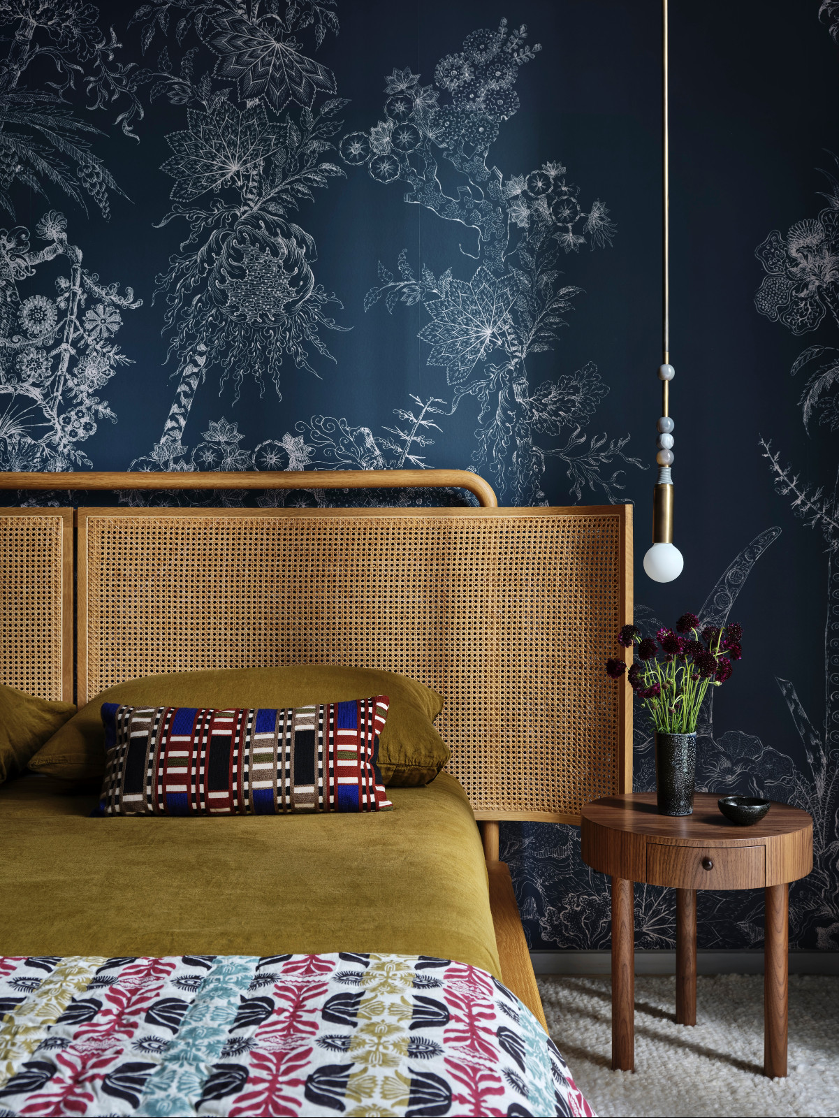 A bedroom with a botanical, jewel-toned wallpaper at a pied-à-terre above the High Line in New York City designed by Lucy Harris