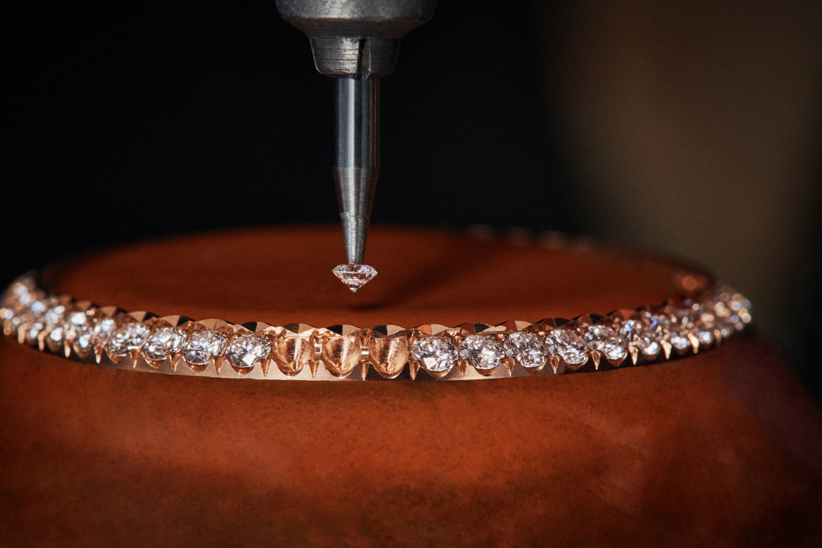 Setting diamonds on the pink gold bezel