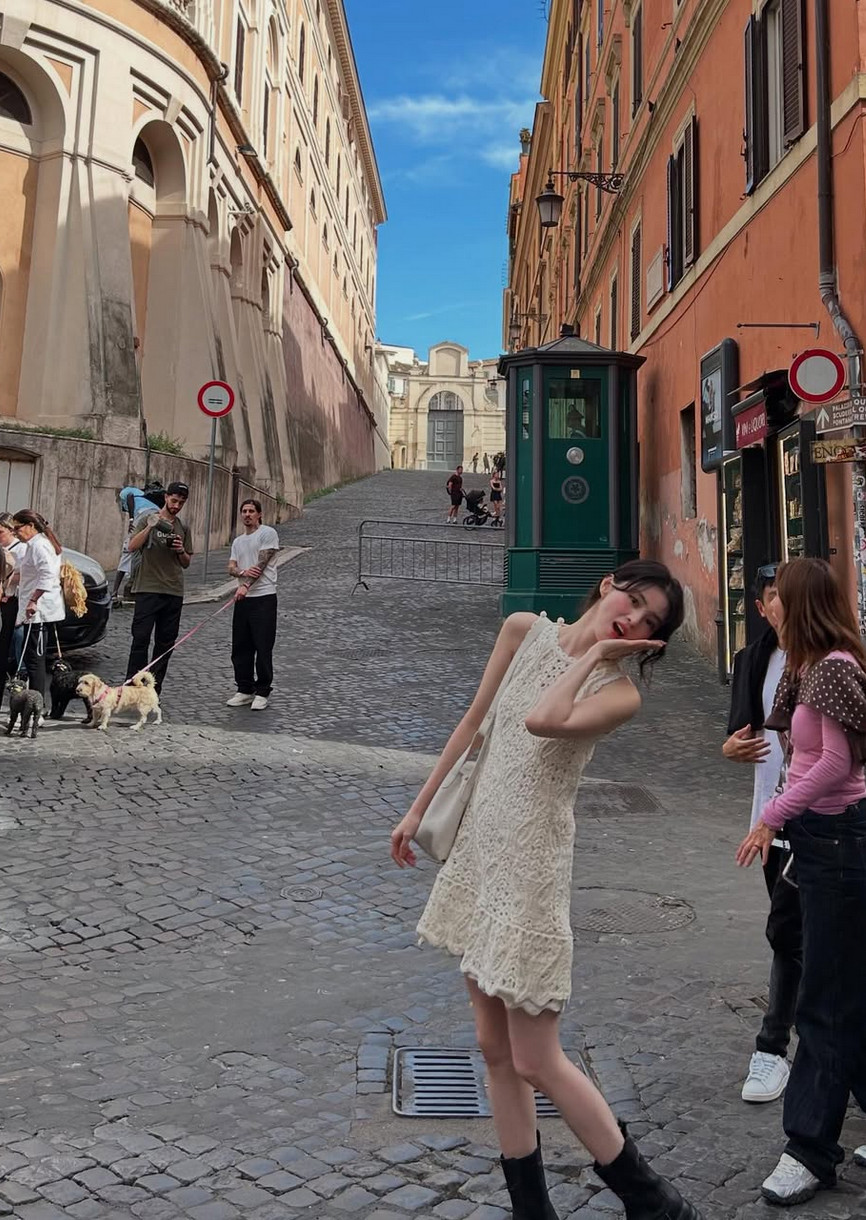 A white crochet dress meets platform boots on Roman cobblestones (Photo: @xeesoxee / Instagram)