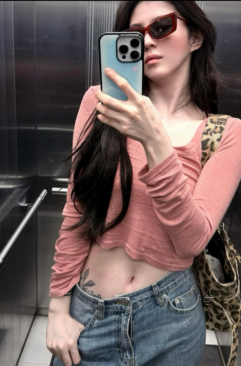 Her pink crop top and low-rise jeans deliberately frame her waist tattoo (Photo: @xeesoxee / Instagram)
