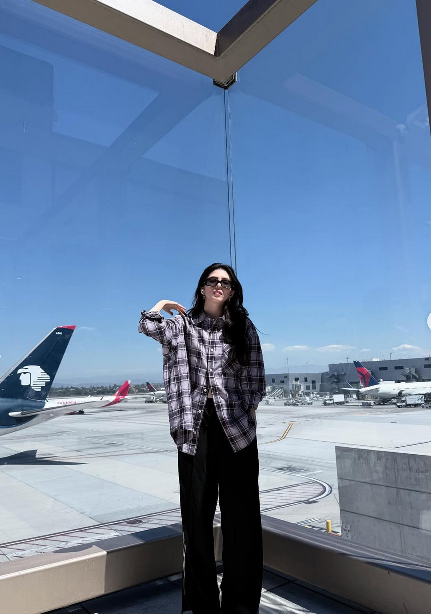 Her oversized plaid flannel embodies effortless cool for airport fashion moments (Photo: @xeesoxee / Instagram)
