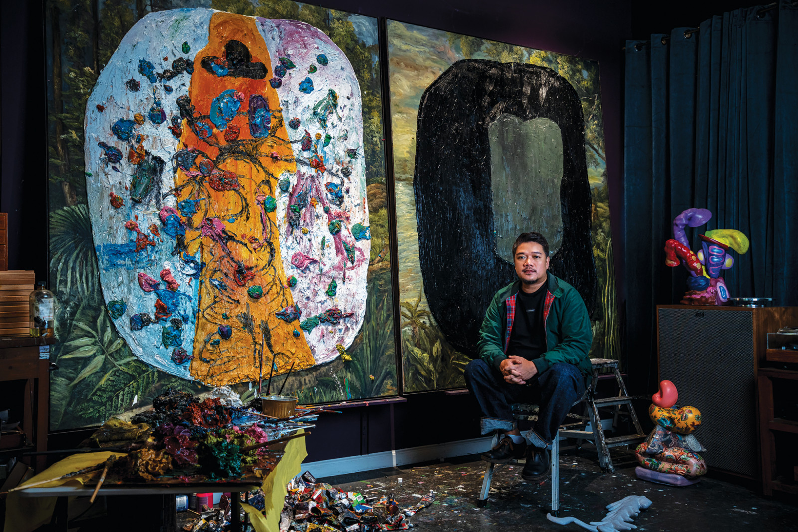 Jigger Cruz with his artworks titled, 'Lonely Man’s Paradise' (left) and 'Halo in a Folklore Alley' (Photo: Toto Labrador)