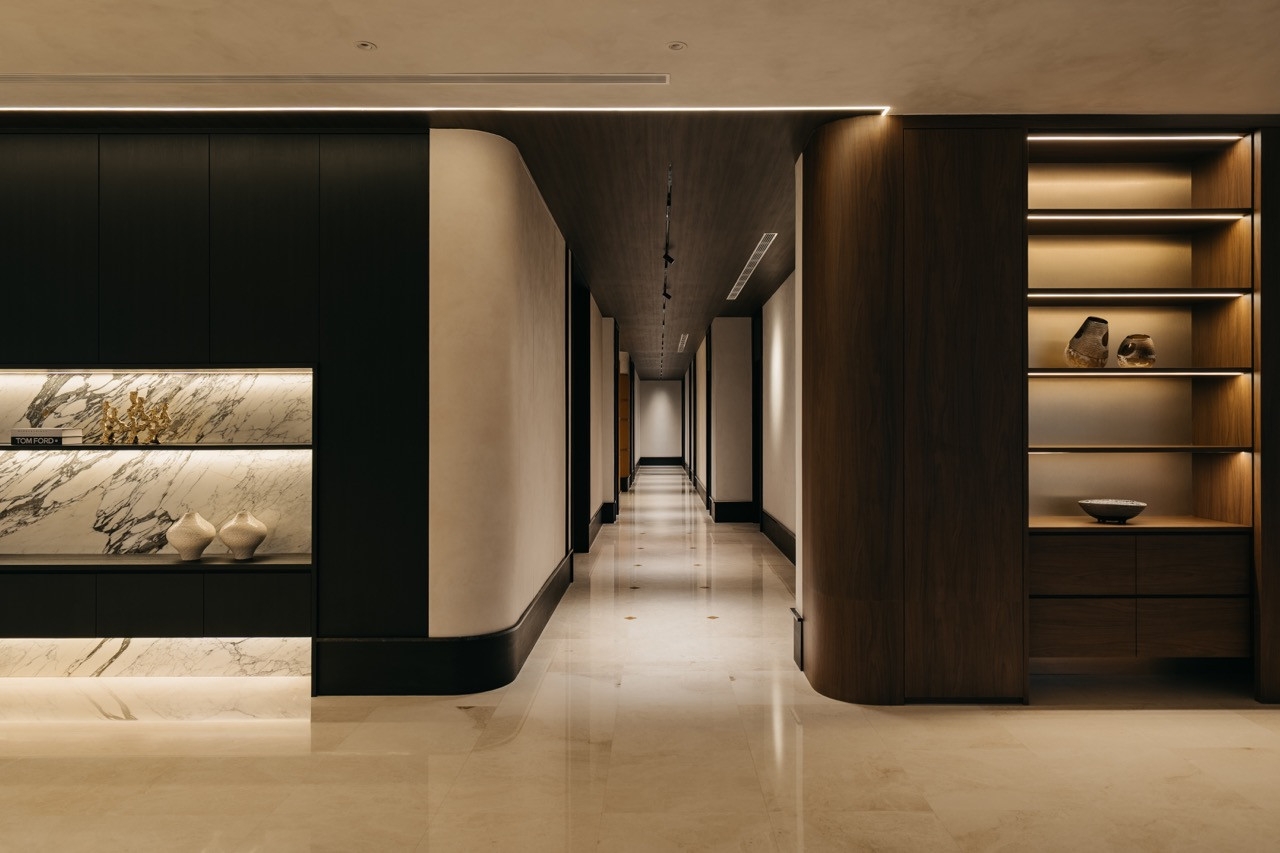 The hallway includes integrated display shelving with marble backing and timber storage
