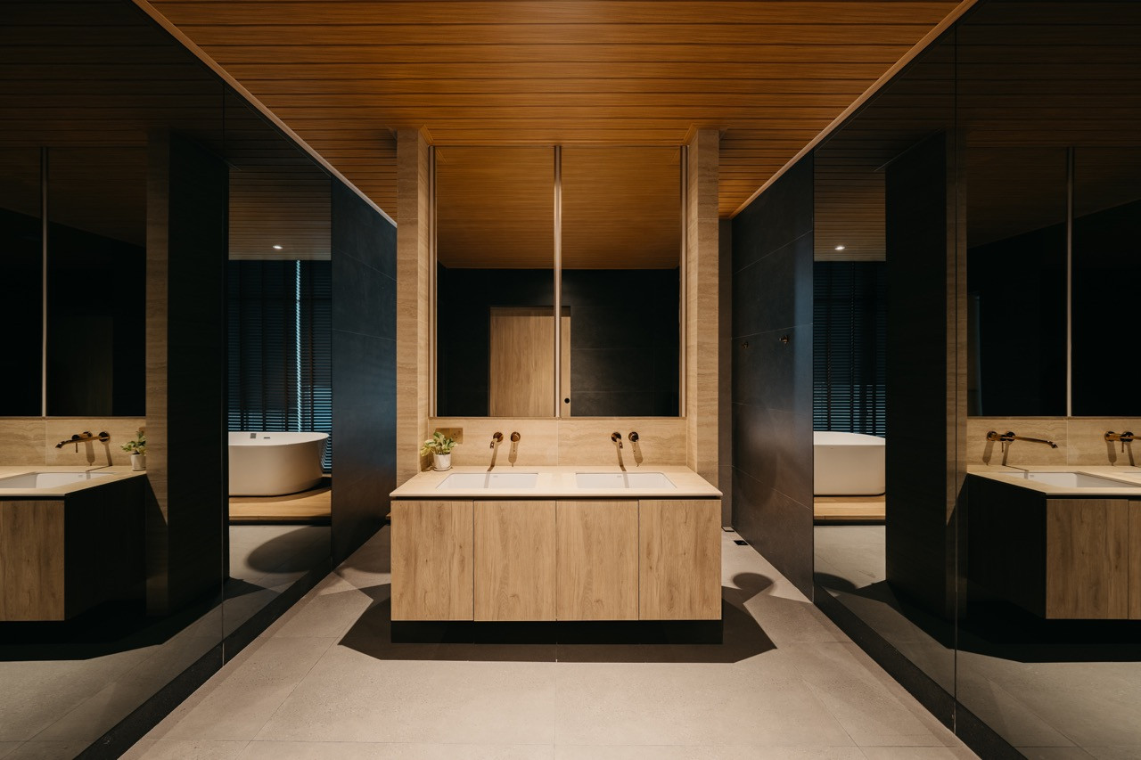 A central vanity unit with double basins, brass fixtures and floor-to-ceiling mirrors