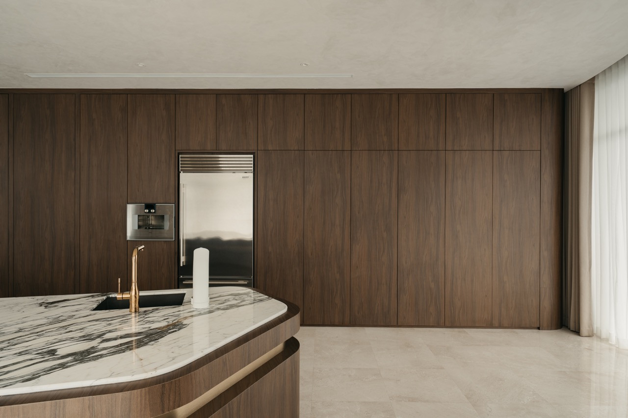 The kitchen cabinetry wall integrates appliances within timber panels