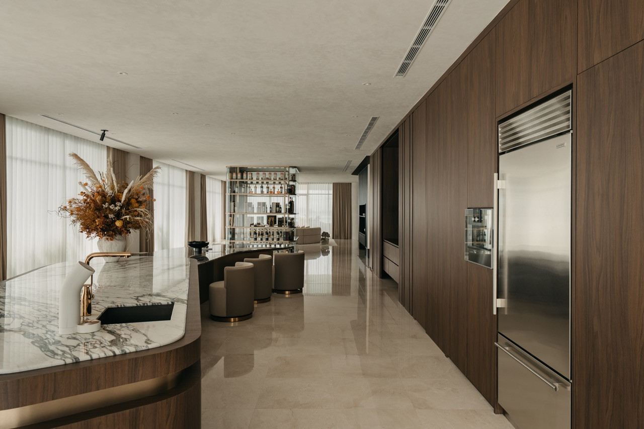 The view from the kitchen area shows the full length of the open-plan area, with the curved counter and the living and spirits visible